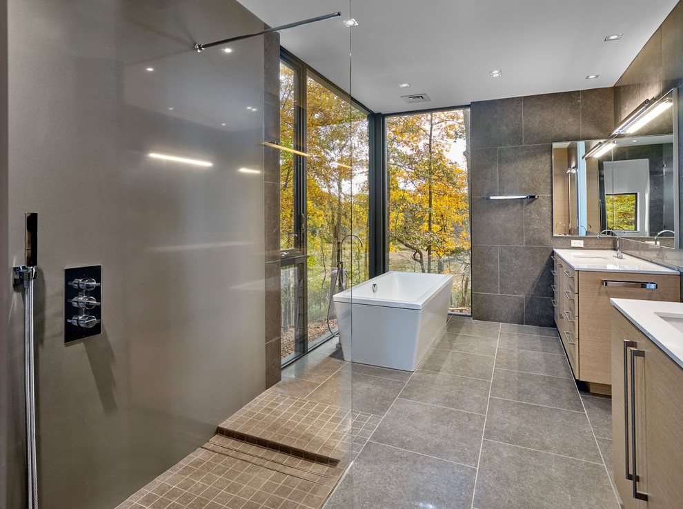 Идея дизайна: главная ванная комната в современном стиле с плоскими фасадами, светлыми деревянными фасадами, отдельно стоящей ванной, душем без бортиков, серой плиткой, врезной раковиной, серым полом и открытым душем