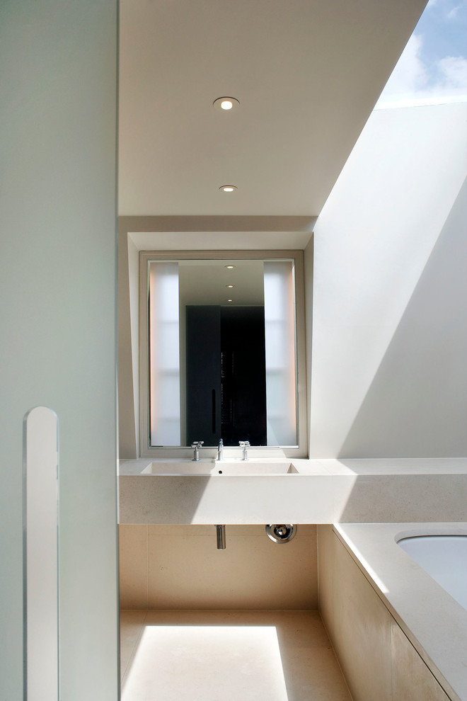 Immagine di una stanza da bagno moderna con lavabo integrato e vasca sottopiano