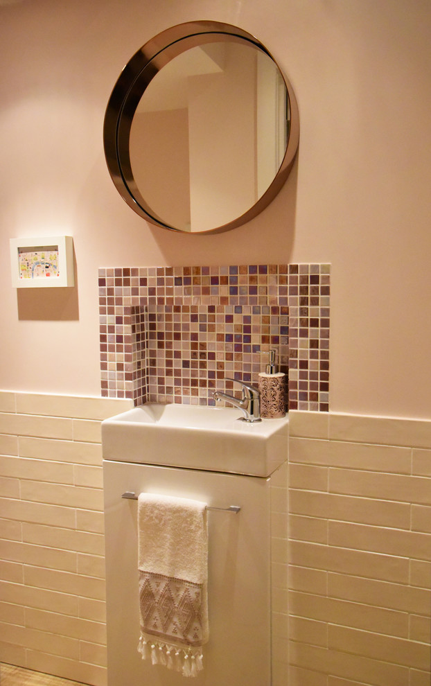 Идея дизайна: ванная комната в современном стиле с плоскими фасадами, белыми фасадами, раздельным унитазом, розовой плиткой, плиткой мозаикой, розовыми стенами и полом из ламината