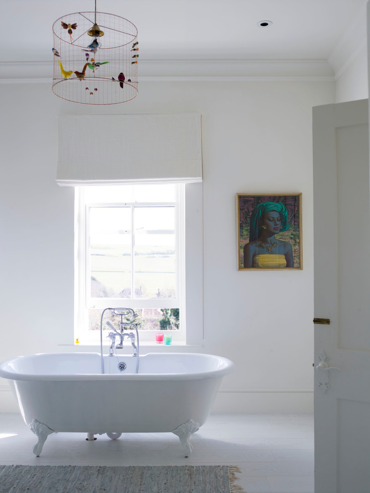 This is an example of an eclectic bathroom in Sussex with freestanding cabinets, white cabinets, marble worktops, a freestanding bath, a built-in shower, white tiles, ceramic tiles, white walls and light hardwood flooring.