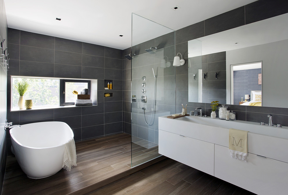 Bathroom - mid-sized contemporary master gray tile medium tone wood floor and brown floor bathroom idea in Boston with a trough sink, flat-panel cabinets, white cabinets, quartz countertops and gray walls