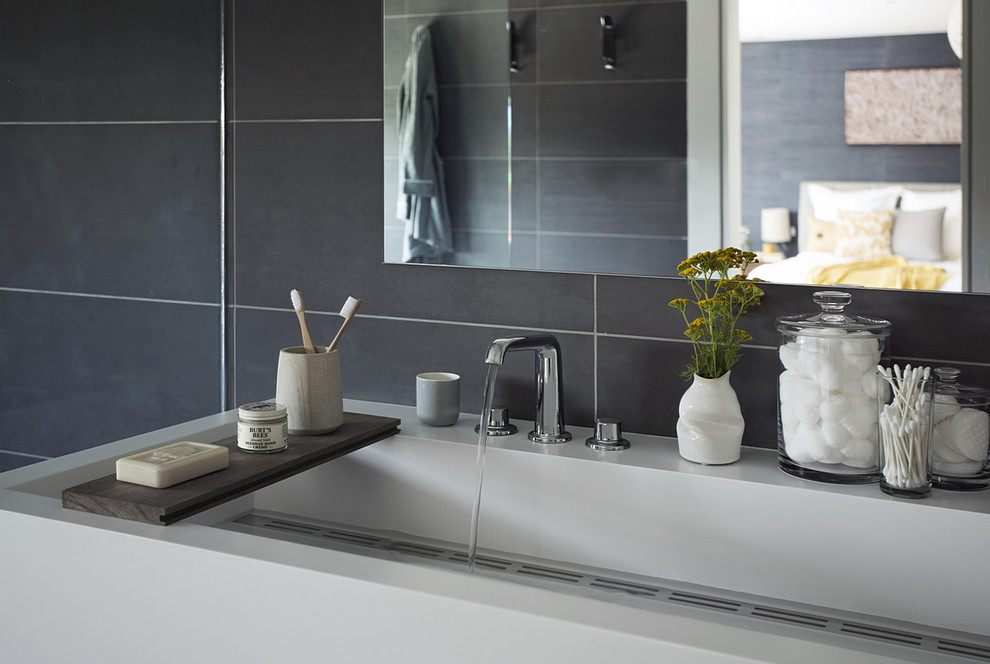 Immagine di una stanza da bagno padronale minimal con lavabo rettangolare, ante lisce, ante bianche, top in quarzo composito, piastrelle grigie e pareti grigie
