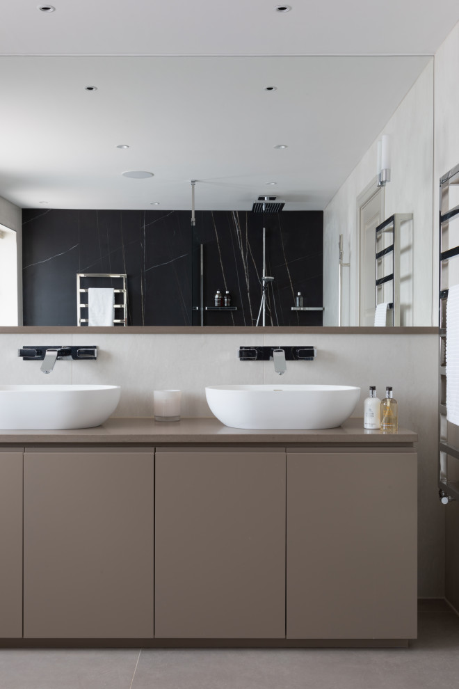 Design ideas for a large contemporary ensuite bathroom in Hertfordshire with beige cabinets, a one-piece toilet, porcelain tiles, porcelain flooring, quartz worktops, beige worktops, flat-panel cabinets, a vessel sink, grey floors and double sinks.