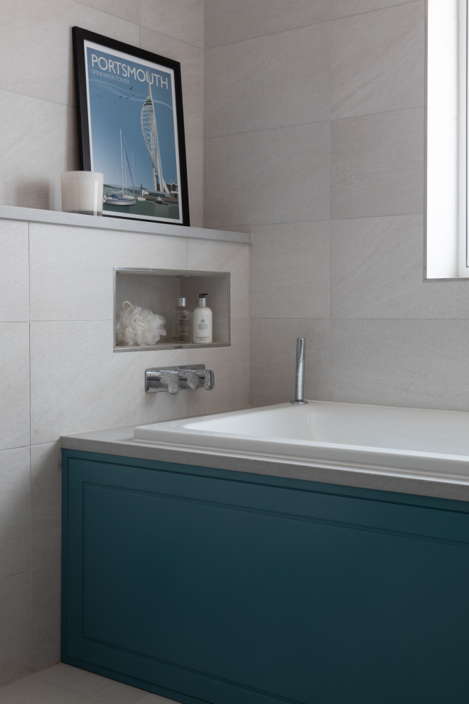 Inspiration for a medium sized contemporary ensuite bathroom in Hertfordshire with grey cabinets, a built-in bath, an alcove shower, a one-piece toilet, grey tiles, porcelain tiles, grey walls, porcelain flooring, a wall-mounted sink, quartz worktops, grey floors, a hinged door and grey worktops.
