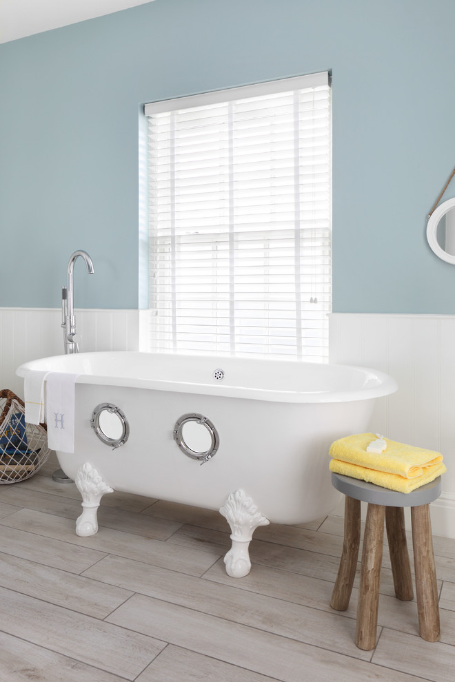 Claw-foot bathtub - mid-sized coastal master light wood floor and beige floor claw-foot bathtub idea in London with blue walls
