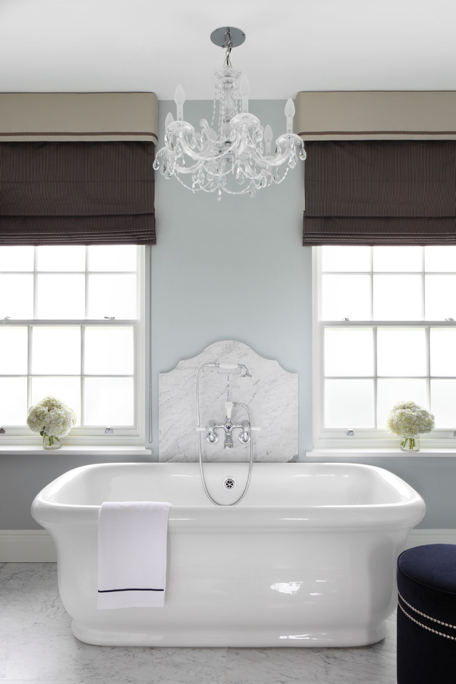 Elegant master marble floor freestanding bathtub photo in London with gray walls