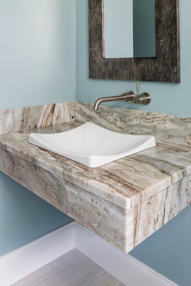 Cette image montre une petite salle de bain minimaliste avec un lavabo suspendu, un plan de toilette en quartz et un mur bleu.