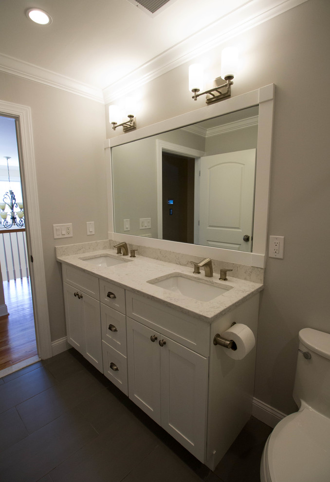 Medium sized traditional family bathroom in New York with shaker cabinets, white cabinets, an alcove bath, an alcove shower, a two-piece toilet, white tiles, ceramic tiles, grey walls, porcelain flooring, a submerged sink, engineered stone worktops, grey floors and a shower curtain.
