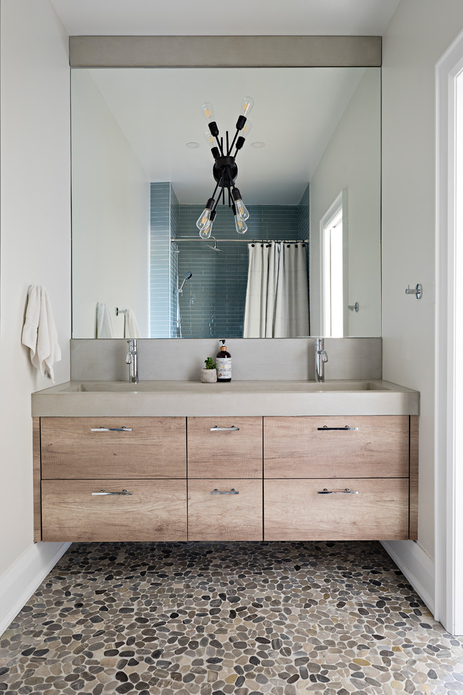 Cette image montre une douche en alcôve rustique en bois clair avec un placard à porte plane, un mur gris, un sol en galet, un sol multicolore, un plan de toilette gris, un carrelage bleu, une cabine de douche avec un rideau et une grande vasque.