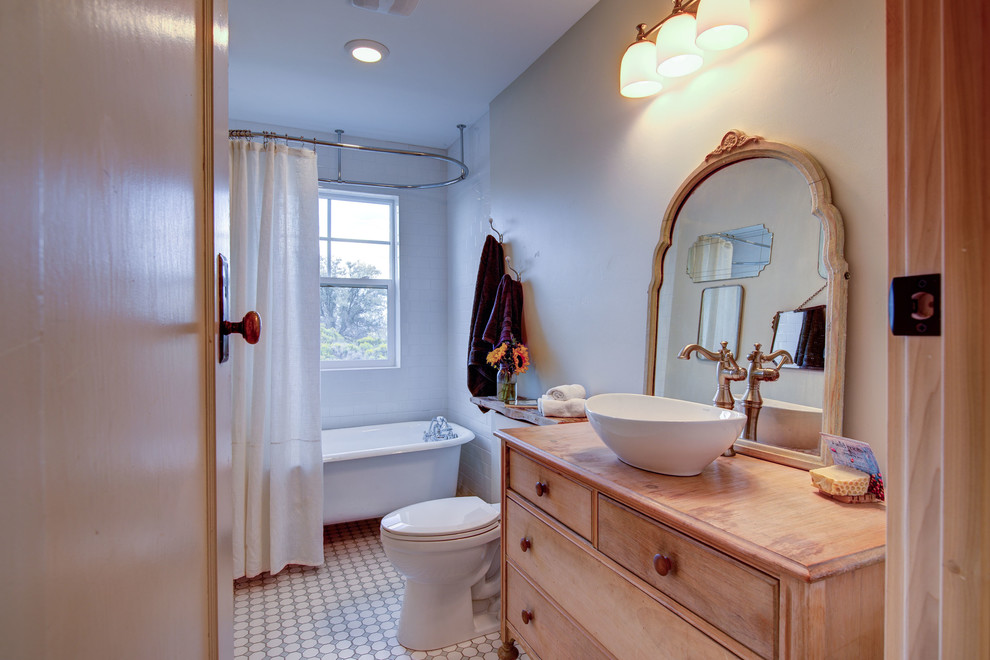 Exempel på ett shabby chic-inspirerat beige beige badrum med dusch, med möbel-liknande, skåp i ljust trä, ett fristående badkar, en toalettstol med separat cisternkåpa, beige väggar, ett fristående handfat, träbänkskiva, flerfärgat golv och dusch med duschdraperi