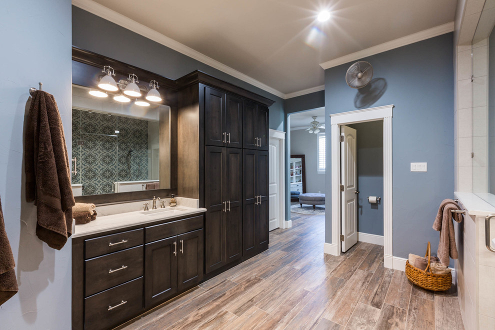 Inspiration for a country master black tile and porcelain tile porcelain tile and brown floor walk-in shower remodel in Dallas with raised-panel cabinets, dark wood cabinets, a two-piece toilet, blue walls, an undermount sink, quartz countertops, a hinged shower door and white countertops