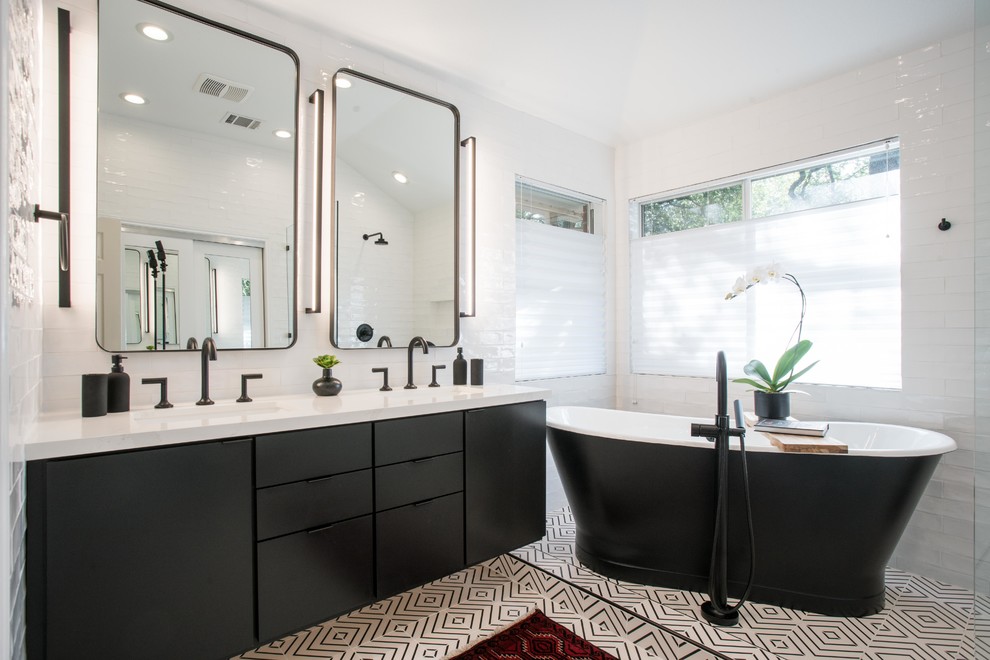 Exempel på ett modernt vit vitt en-suite badrum, med släta luckor, svarta skåp, ett fristående badkar, vit kakel, porslinskakel, vita väggar, ett undermonterad handfat, bänkskiva i kvarts, vitt golv och cementgolv