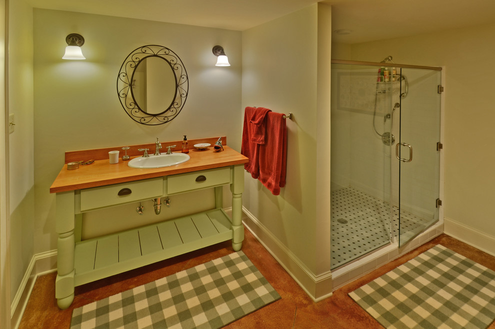 Cette photo montre une salle de bain nature avec un placard à porte plane, des portes de placards vertess, une douche d'angle, un carrelage blanc, un carrelage métro, un lavabo posé, un plan de toilette en bois, un mur blanc et sol en béton ciré.