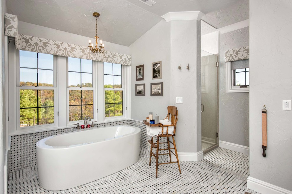 Modelo de cuarto de baño principal y gris y blanco tradicional con bañera exenta, paredes grises, suelo de baldosas de cerámica, ducha esquinera, ducha con puerta con bisagras y ventanas