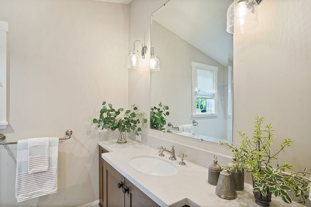 Idée de décoration pour une grande salle de bain champêtre en bois brun avec un placard à porte shaker, un carrelage gris, un mur gris, un sol en calcaire, un lavabo encastré, un plan de toilette en quartz, un sol gris et un plan de toilette blanc.