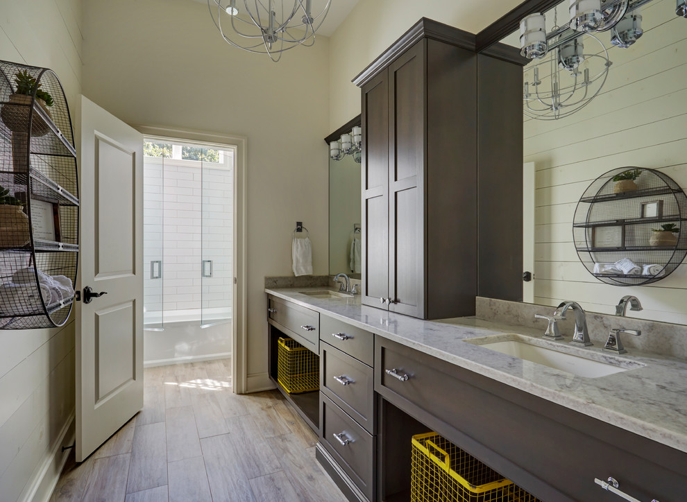 Photo of an expansive rural ensuite bathroom in Chicago with shaker cabinets, brown cabinets, an alcove bath, a shower/bath combination, white tiles, metro tiles, beige walls, medium hardwood flooring, a submerged sink, brown floors, a hinged door, grey worktops and quartz worktops.