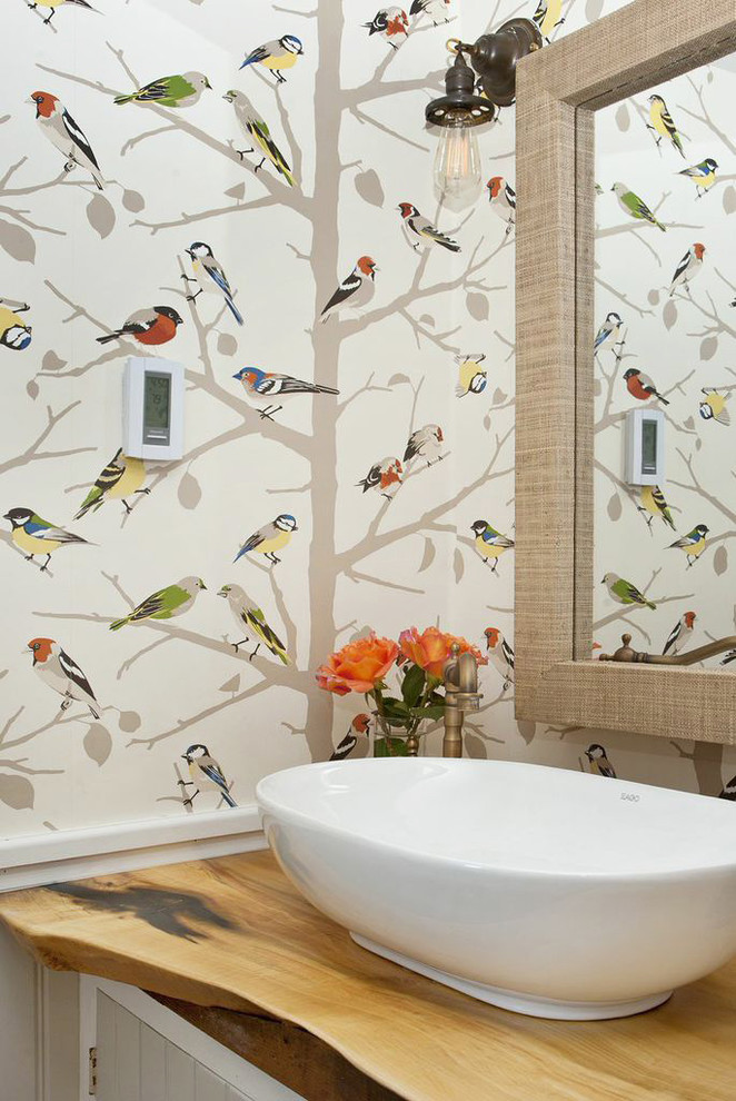 Example of a country bathroom design in New York with a vessel sink, wood countertops and multicolored walls