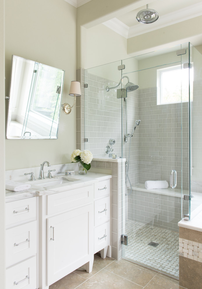 Inredning av ett lantligt badrum, med vita skåp, en dusch i en alkov, grå kakel, beige väggar och luckor med infälld panel