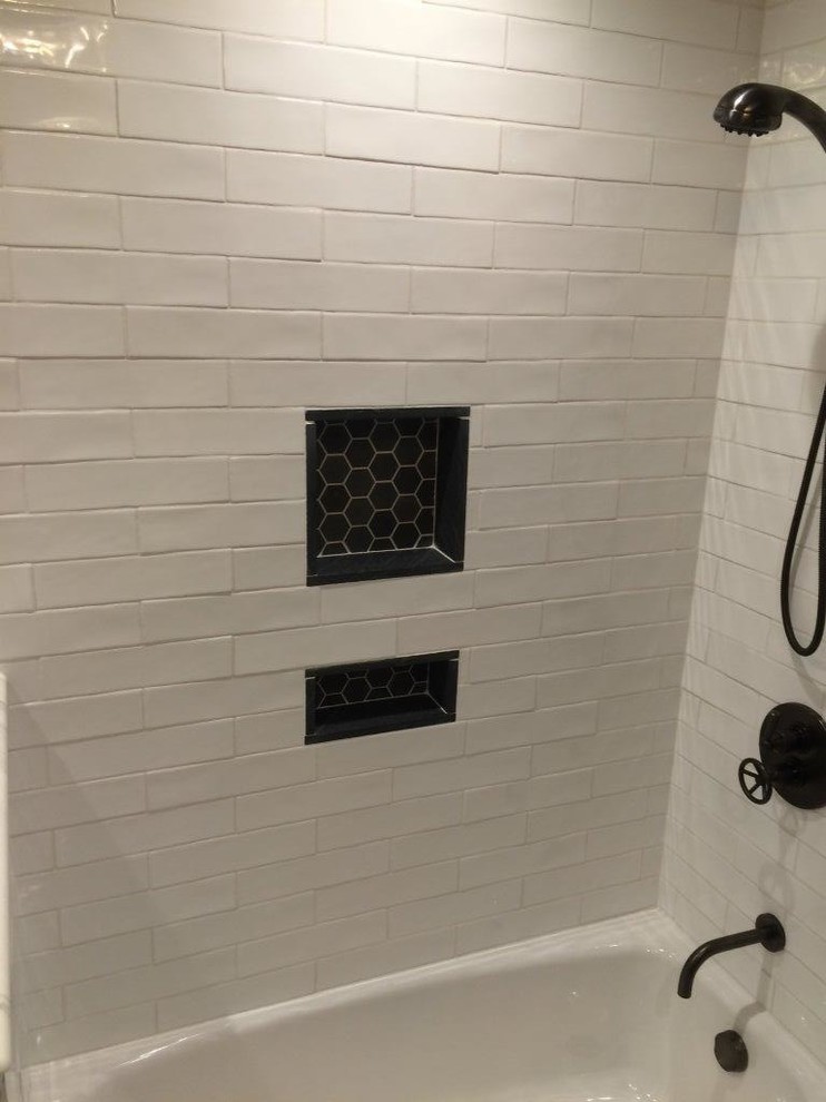 Lantlig inredning av ett badrum, med ett badkar i en alkov, en dusch/badkar-kombination, vit kakel, tunnelbanekakel, grå väggar, mosaikgolv, ett undermonterad handfat och marmorbänkskiva