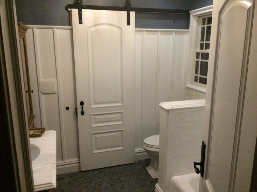 Exemple d'une salle de bain nature avec un sol en carrelage de terre cuite, un plan de toilette en marbre, une baignoire en alcôve, un combiné douche/baignoire, un mur gris, un lavabo encastré, un carrelage blanc et un carrelage métro.