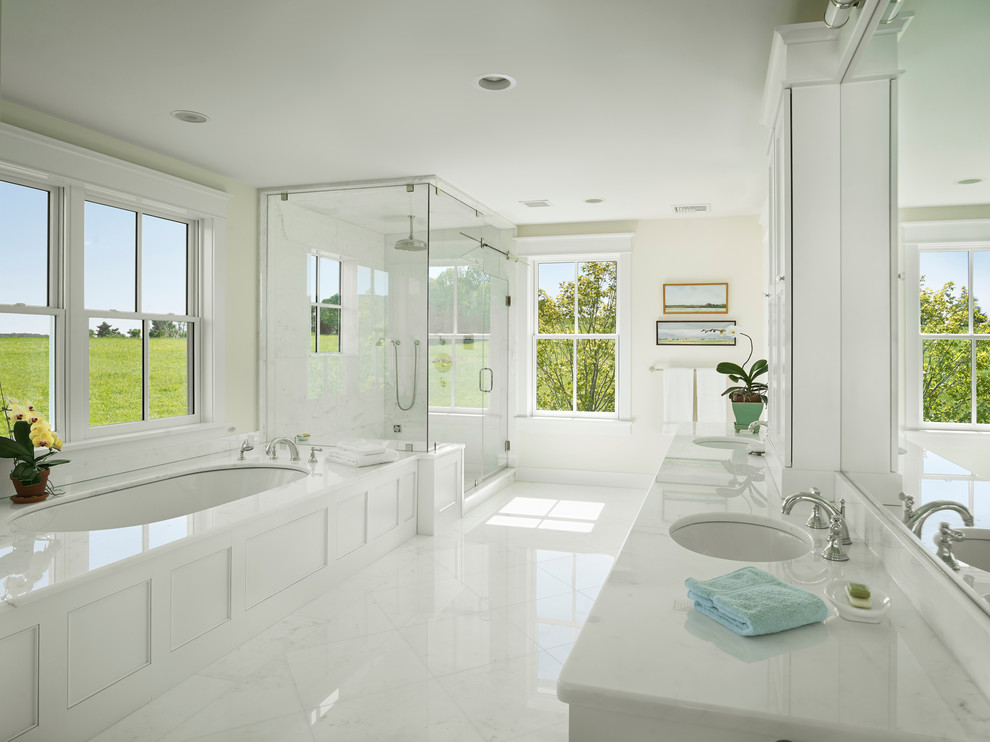ニューヨークにあるカントリー風のおしゃれな浴室 (アンダーカウンター洗面器、コーナー設置型シャワー、白いタイル、アンダーマウント型浴槽、白い床、白い洗面カウンター) の写真