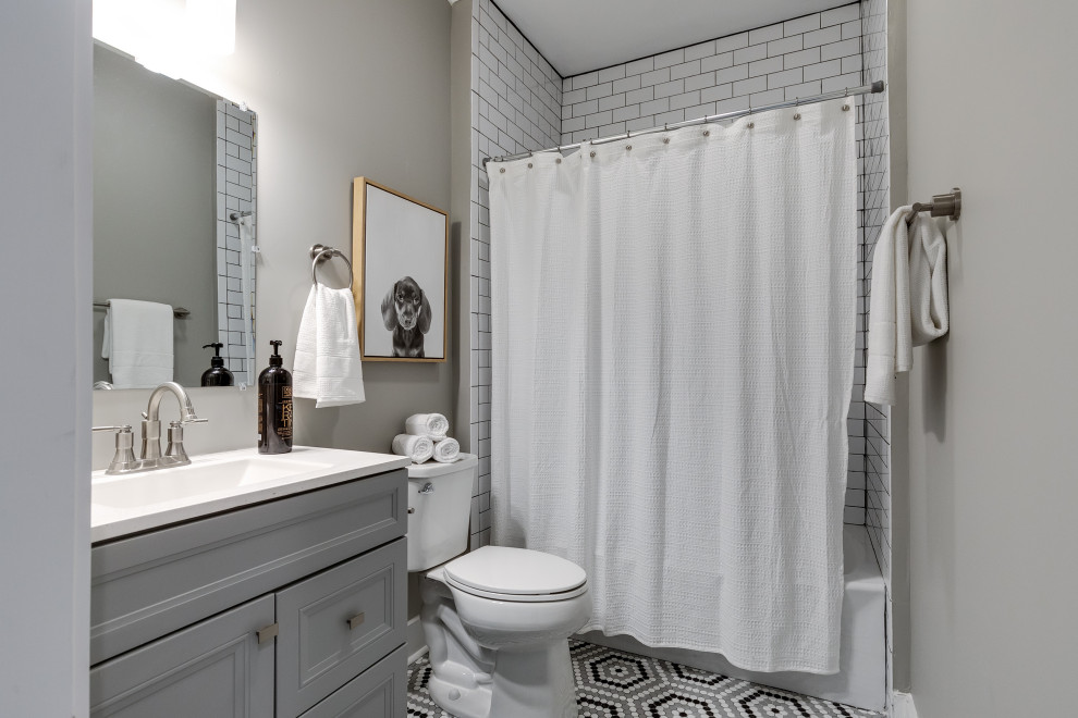 Inspiration för ett lantligt vit vitt badrum, med luckor med infälld panel, grå skåp, ett badkar i en alkov, en dusch/badkar-kombination, en toalettstol med separat cisternkåpa, vit kakel, grå väggar, mosaikgolv, flerfärgat golv och dusch med duschdraperi