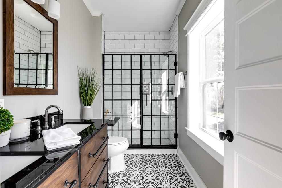 Идея дизайна: ванная комната в стиле кантри с плоскими фасадами, темными деревянными фасадами, душем в нише, белой плиткой, плиткой кабанчик, серыми стенами, врезной раковиной, разноцветным полом, черной столешницей и тумбой под две раковины