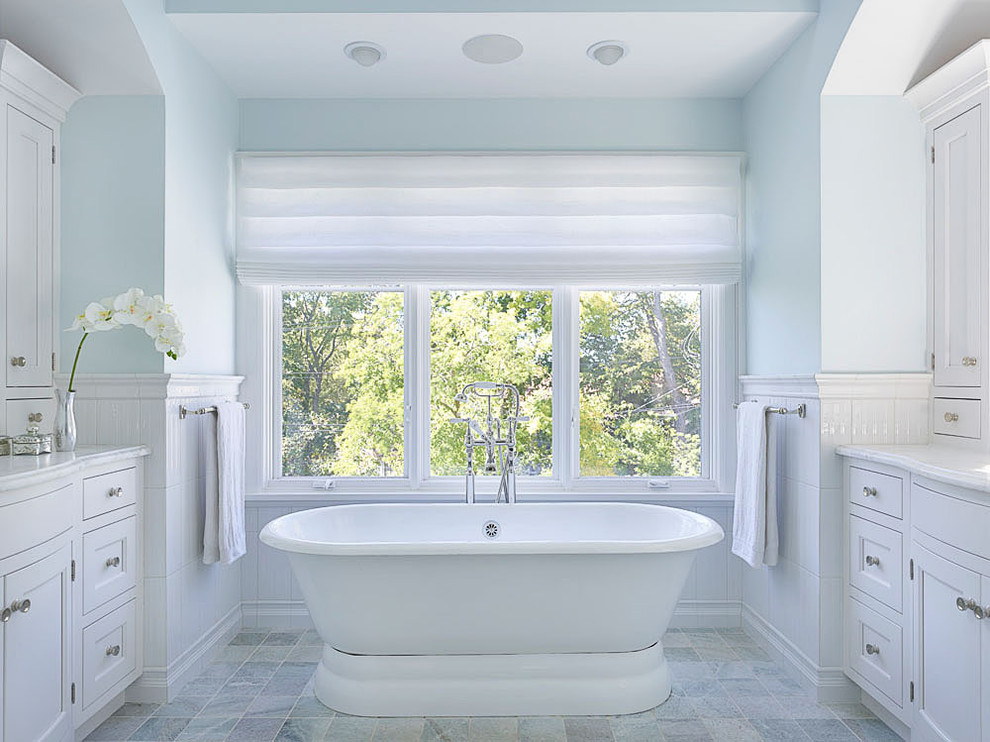 Cette image montre une salle de bain rustique avec un placard avec porte à panneau encastré, des portes de placard blanches et une baignoire indépendante.