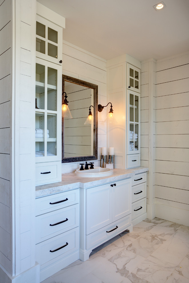 Medium sized rural shower room bathroom in San Francisco with raised-panel cabinets, white cabinets, a freestanding bath, a walk-in shower, a one-piece toilet, grey tiles, white tiles, stone slabs, white walls, porcelain flooring, a built-in sink and granite worktops.