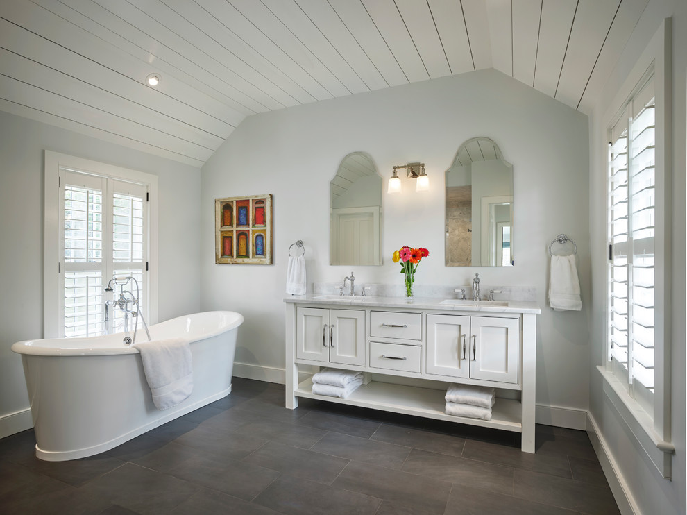 Immagine di una stanza da bagno country con ante bianche, vasca freestanding, pareti grigie, lavabo sottopiano, pavimento grigio, top bianco e ante a filo