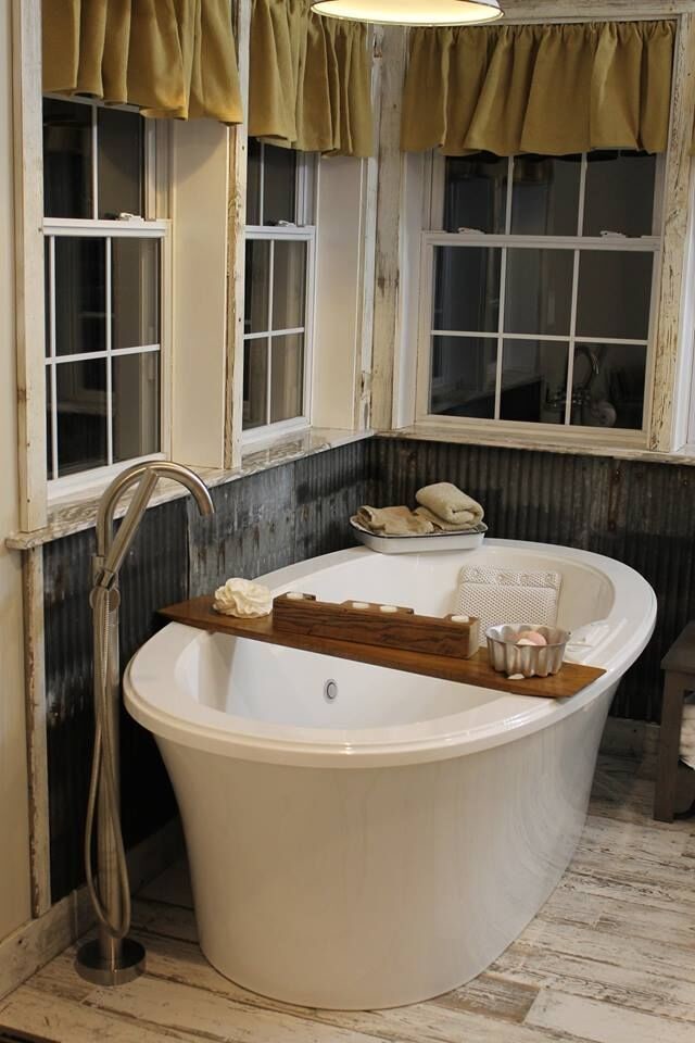 Inredning av ett lantligt en-suite badrum, med ett fristående badkar, grå väggar, ljust trägolv och beiget golv