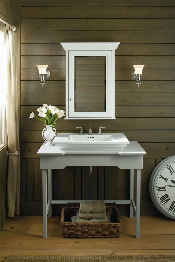 Diseño de cuarto de baño campestre pequeño con armarios tipo mueble, puertas de armario grises, paredes marrones, suelo de madera clara, lavabo sobreencimera y encimera de madera