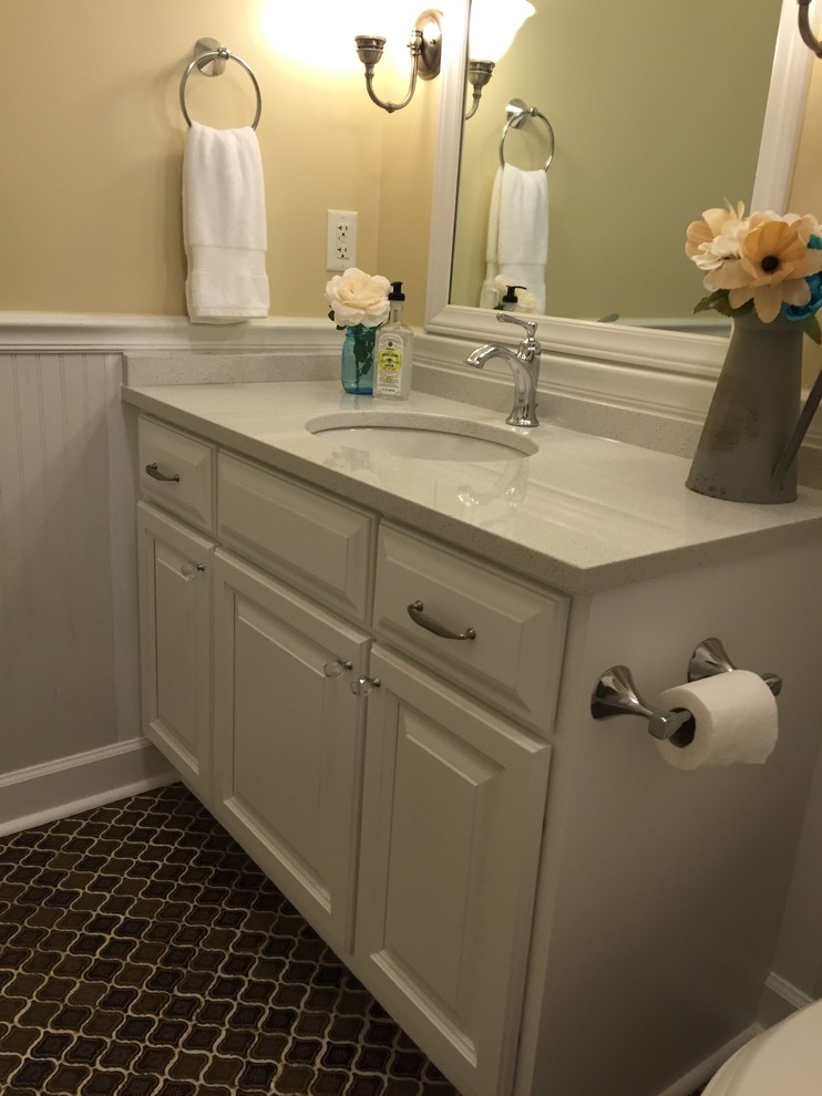 Photo of a medium sized farmhouse bathroom in Charleston with a submerged sink, raised-panel cabinets, white cabinets, quartz worktops, a shower/bath combination, brown tiles, ceramic tiles, yellow walls and ceramic flooring.