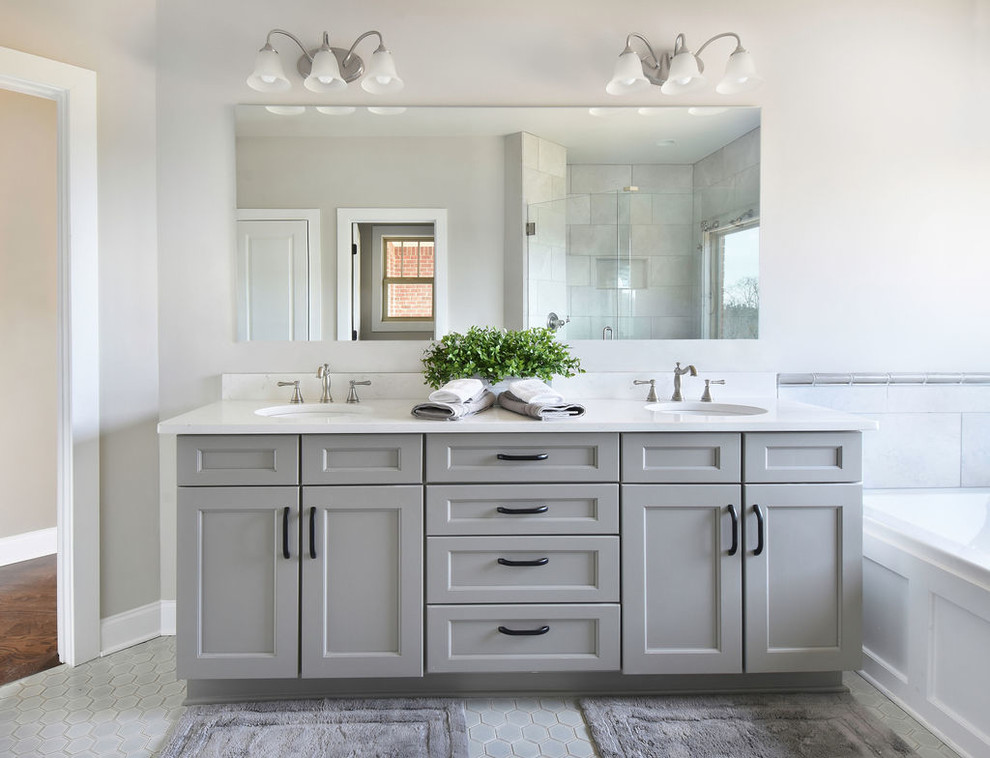 Пример оригинального дизайна: ванная комната в стиле неоклассика (современная классика) с фасадами в стиле шейкер, серыми фасадами, серыми стенами, врезной раковиной, серым полом, белой столешницей и зеркалом с подсветкой