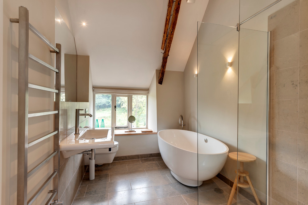 Exempel på ett stort lantligt badrum, med ett fristående badkar, en hörndusch, en vägghängd toalettstol, beige kakel och kakelplattor