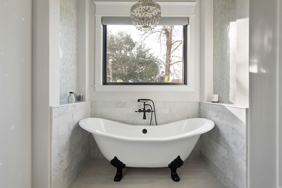 Cette image montre une salle de bain rustique avec une baignoire sur pieds, un mur blanc et un sol blanc.