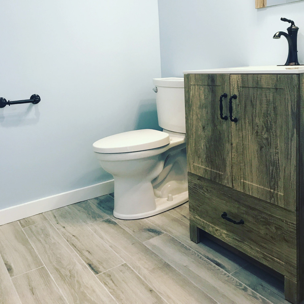 Bild på ett litet lantligt vit vitt badrum, med luckor med infälld panel, skåp i mellenmörkt trä, en toalettstol med separat cisternkåpa, blå väggar, bänkskiva i kvarts och grått golv