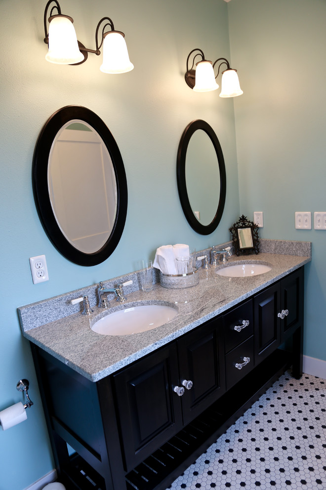 Idée de décoration pour une grande salle de bain principale champêtre avec un lavabo encastré, un placard en trompe-l'oeil, des portes de placard noires, un plan de toilette en granite, un mur bleu et un sol en carrelage de terre cuite.