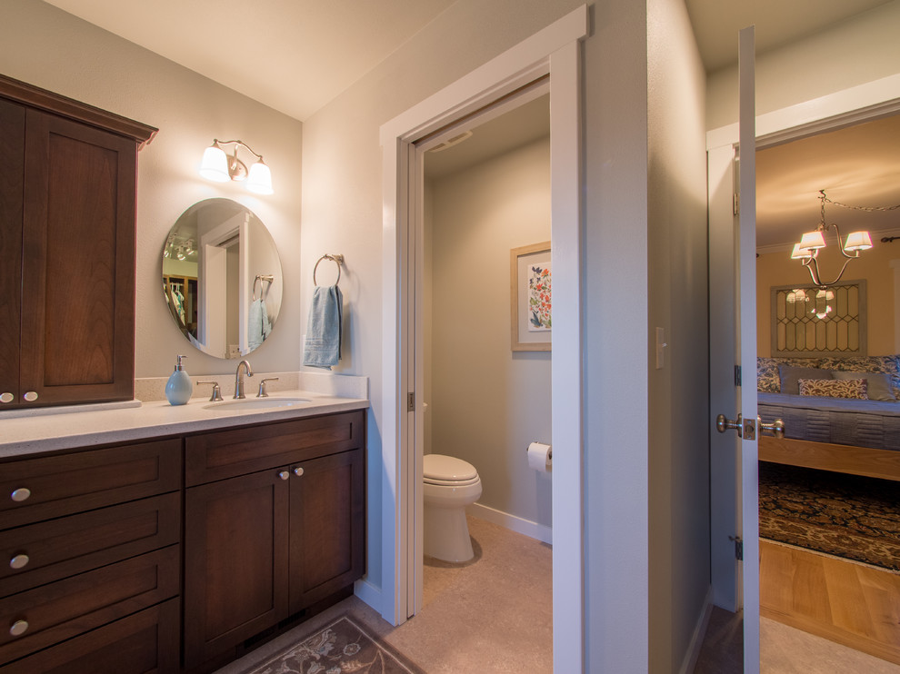 Exemple d'une salle de bain principale nature en bois foncé de taille moyenne avec un placard à porte shaker, une douche double, WC séparés, un carrelage vert, des carreaux de porcelaine, un mur bleu, un sol en linoléum, un lavabo encastré, un plan de toilette en surface solide, un sol beige, une cabine de douche à porte battante, un plan de toilette blanc, des toilettes cachées, meuble double vasque et meuble-lavabo encastré.