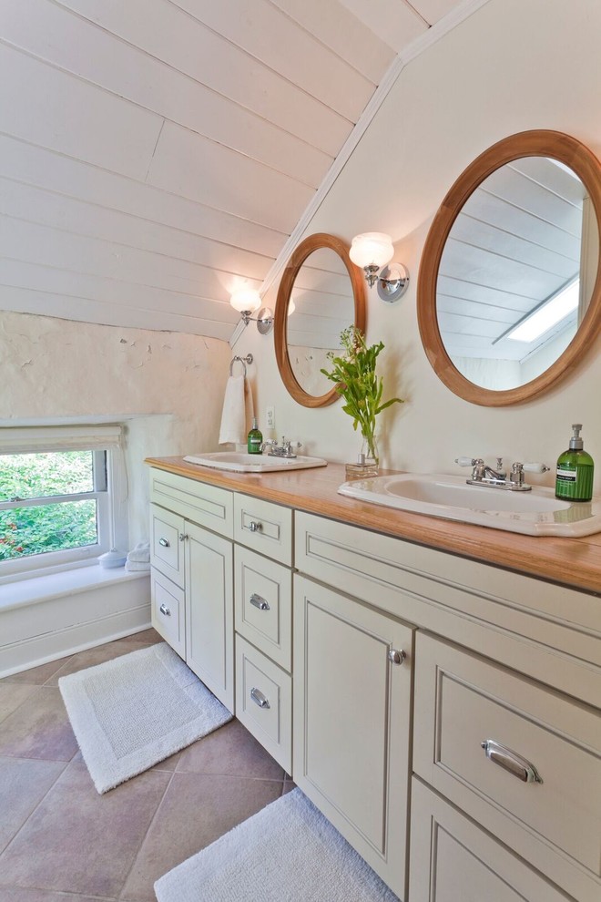 Idéer för stora lantliga en-suite badrum, med luckor med infälld panel, vita skåp, vita väggar, klinkergolv i porslin, ett nedsänkt handfat, träbänkskiva och beiget golv