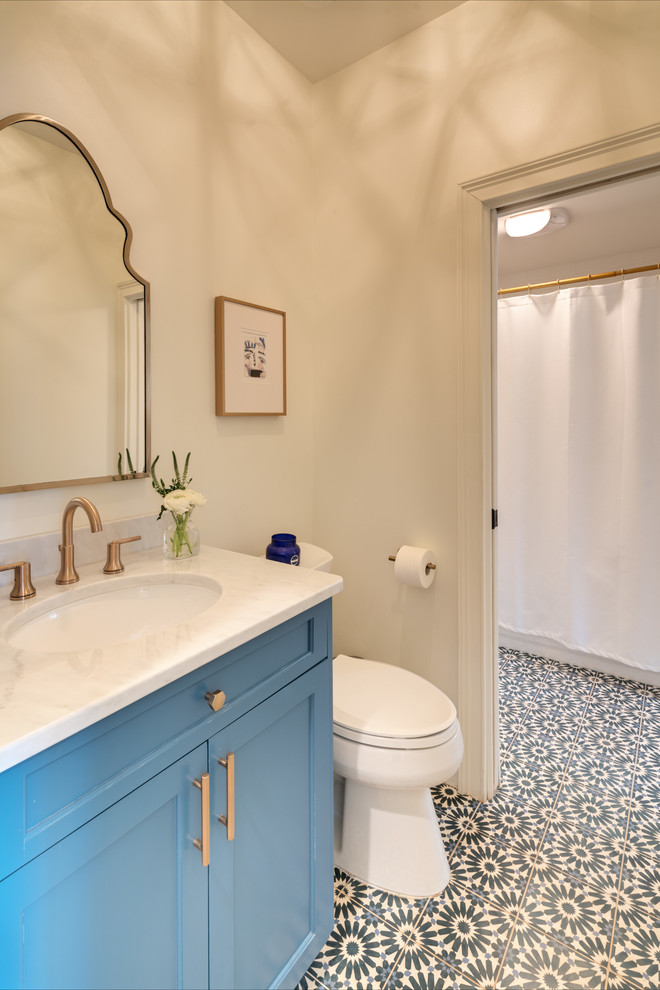Immagine di una stanza da bagno country con ante in stile shaker, ante blu, doccia alcova, WC a due pezzi, pareti bianche, lavabo sottopiano, pavimento multicolore, doccia con tenda e top bianco