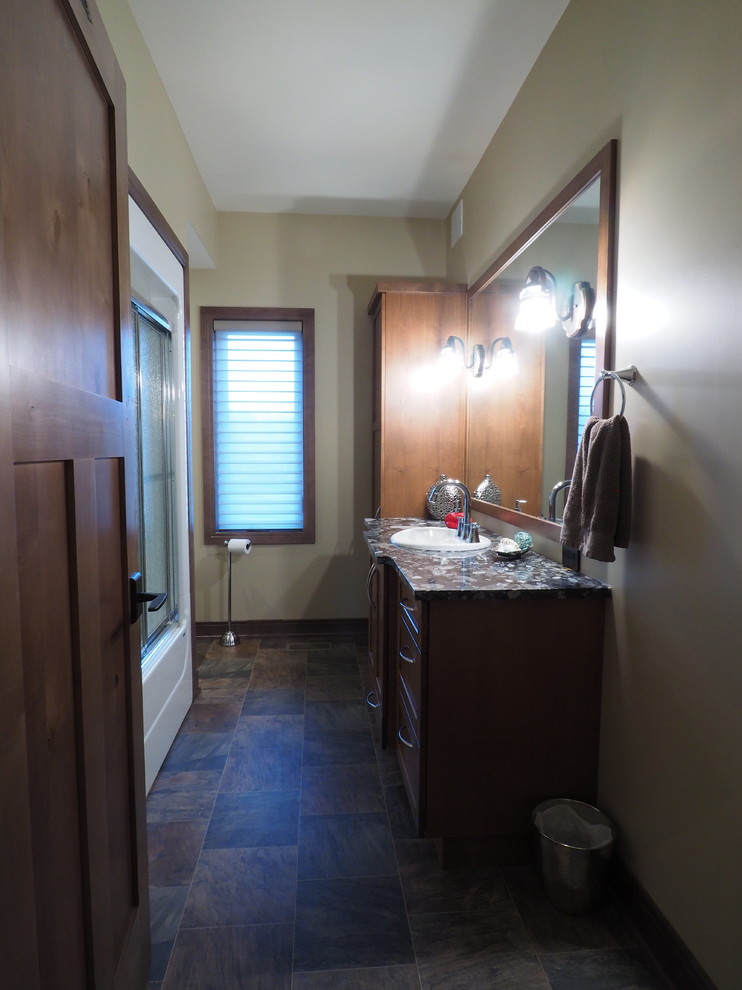 Large rural family bathroom in Other with recessed-panel cabinets, dark wood cabinets, a shower/bath combination, a one-piece toilet, beige walls, lino flooring, a built-in sink, granite worktops, multi-coloured floors, a sliding door and beige worktops.