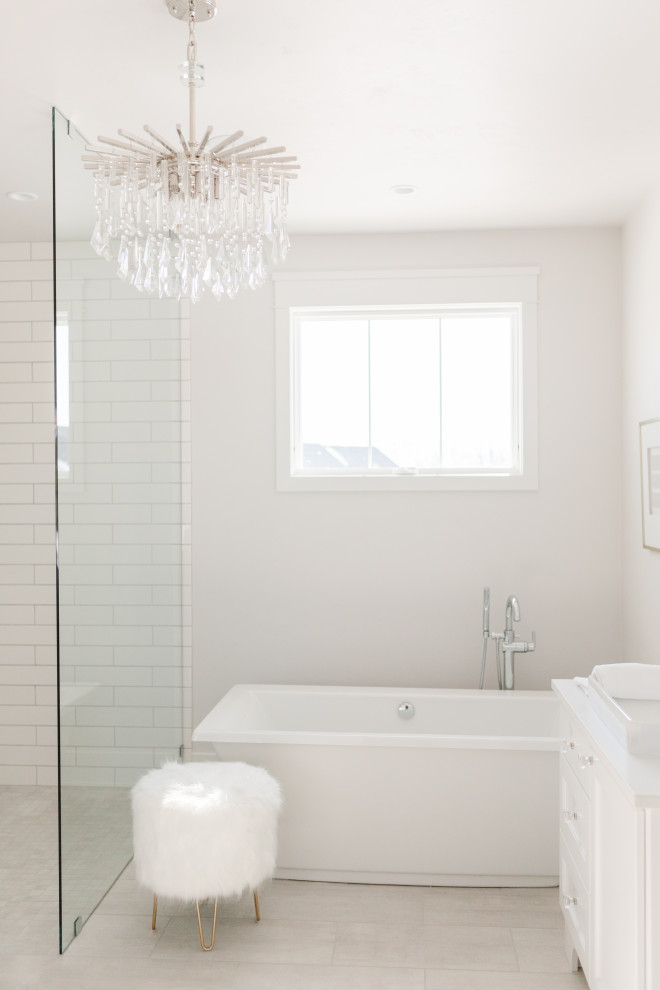 Exempel på ett stort lantligt vit vitt en-suite badrum, med luckor med upphöjd panel, vita skåp, ett fristående badkar, en öppen dusch, en toalettstol med separat cisternkåpa, beige kakel, porslinskakel, vita väggar, klinkergolv i porslin, ett fristående handfat, bänkskiva i kvarts, beiget golv och med dusch som är öppen