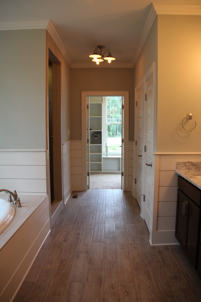 Farmhouse ensuite bathroom in Raleigh with recessed-panel cabinets, dark wood cabinets, a walk-in shower, beige tiles, metro tiles, grey walls, ceramic flooring, a submerged sink, marble worktops and brown floors.