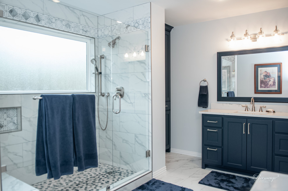 Стильный дизайн: главная ванная комната среднего размера в стиле кантри с фасадами в стиле шейкер, синими фасадами, душем в нише, раздельным унитазом, разноцветной плиткой, мраморной плиткой, синими стенами, мраморным полом, врезной раковиной, столешницей из кварцита, разноцветным полом, душем с распашными дверями, разноцветной столешницей, сиденьем для душа, тумбой под одну раковину и напольной тумбой - последний тренд
