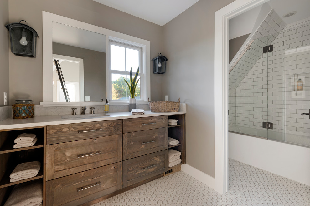 Mid-sized country 3/4 subway tile porcelain tile and white floor bathroom photo in Minneapolis with medium tone wood cabinets, an undermount sink, quartz countertops, a hinged shower door and white countertops