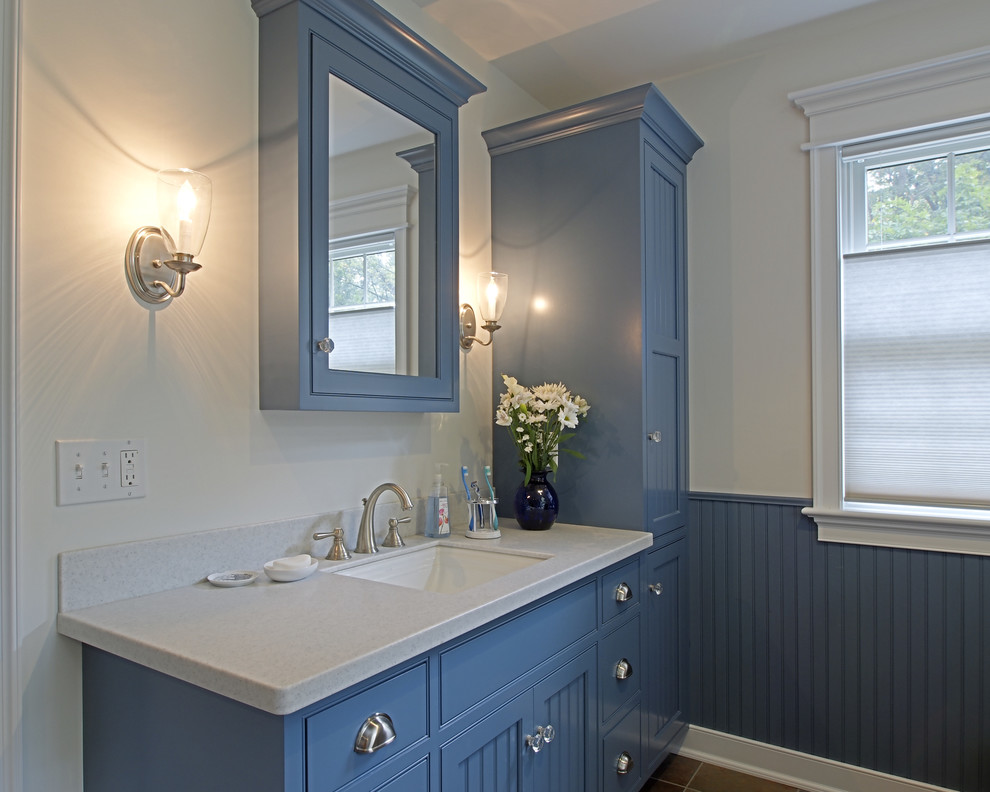 Diseño de cuarto de baño de estilo americano de tamaño medio con armarios estilo shaker, puertas de armario azules, bañera encastrada, paredes blancas, suelo de pizarra, lavabo bajoencimera y encimera de acrílico