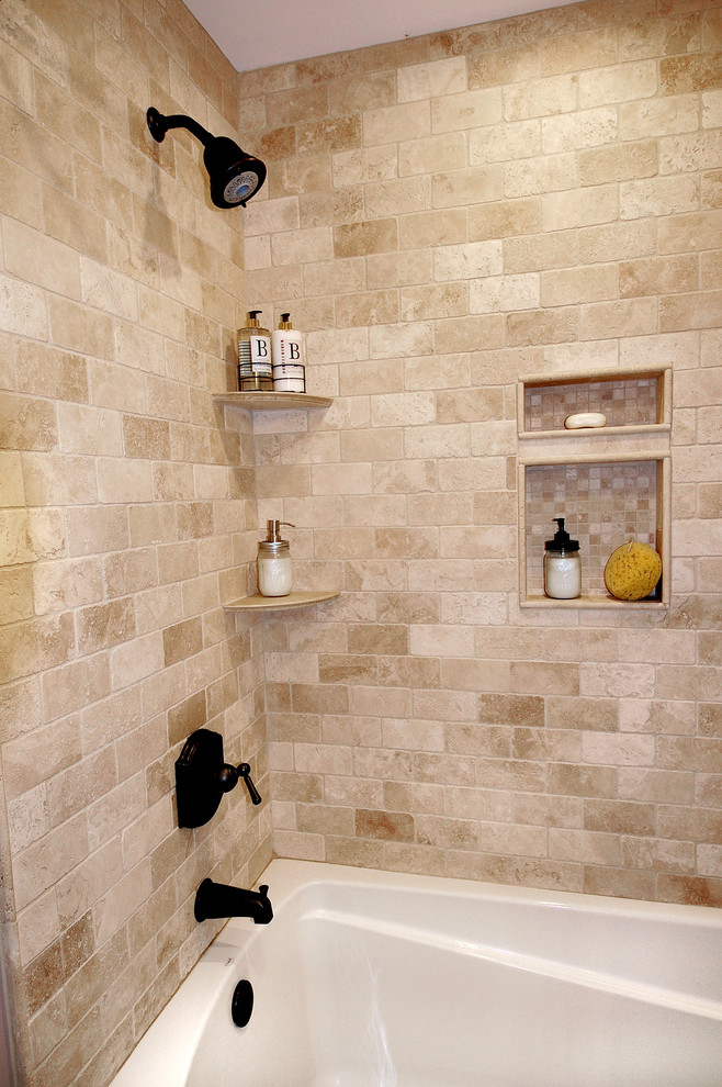 Пример оригинального дизайна: главная ванная комната среднего размера в стиле рустика с фасадами островного типа, искусственно-состаренными фасадами, ванной в нише, душем в нише, раздельным унитазом, бежевой плиткой, каменной плиткой, бежевыми стенами, полом из керамогранита, врезной раковиной, столешницей из гранита, серым полом и шторкой для ванной