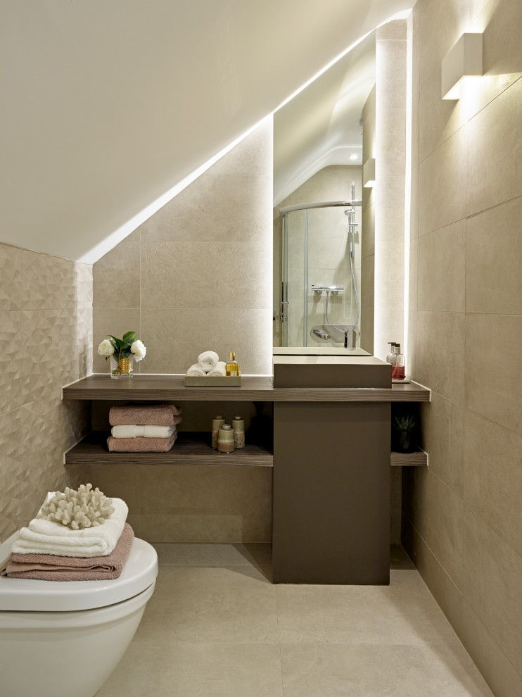 Photo of a contemporary shower room bathroom in London with flat-panel cabinets, brown cabinets, a corner shower, a wall mounted toilet, beige tiles, beige walls, a built-in sink, wooden worktops, beige floors, a hinged door, brown worktops and a vaulted ceiling.