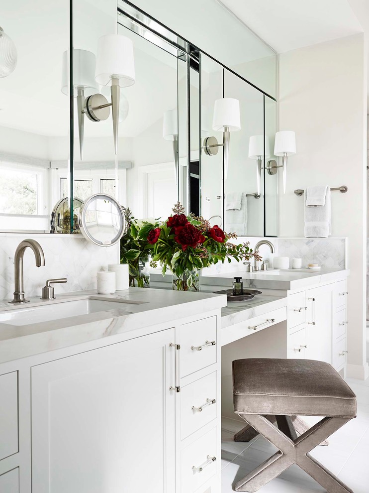 Klassisk inredning av ett stort vit vitt en-suite badrum, med luckor med infälld panel, vita skåp, ett undermonterat badkar, en dubbeldusch, en toalettstol med hel cisternkåpa, vita väggar, klinkergolv i keramik, ett undermonterad handfat, marmorbänkskiva, vitt golv och dusch med gångjärnsdörr